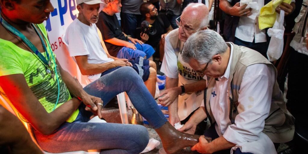 Padilha lava pés de moradores de rua ao lado do padre Júlio Lancellotti